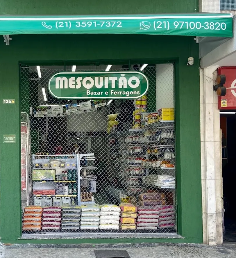 Fachada do Mesquitão Bazar e Ferragens, com toldo verde que exibe o telefone e o WhatsApp da loja